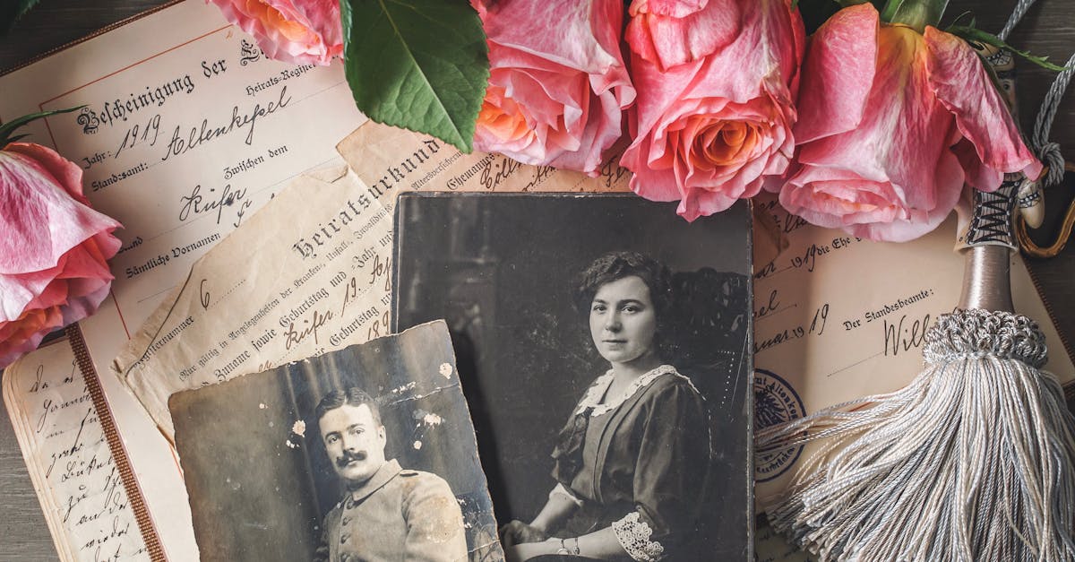Antique family photographs with pink roses and historic documents.